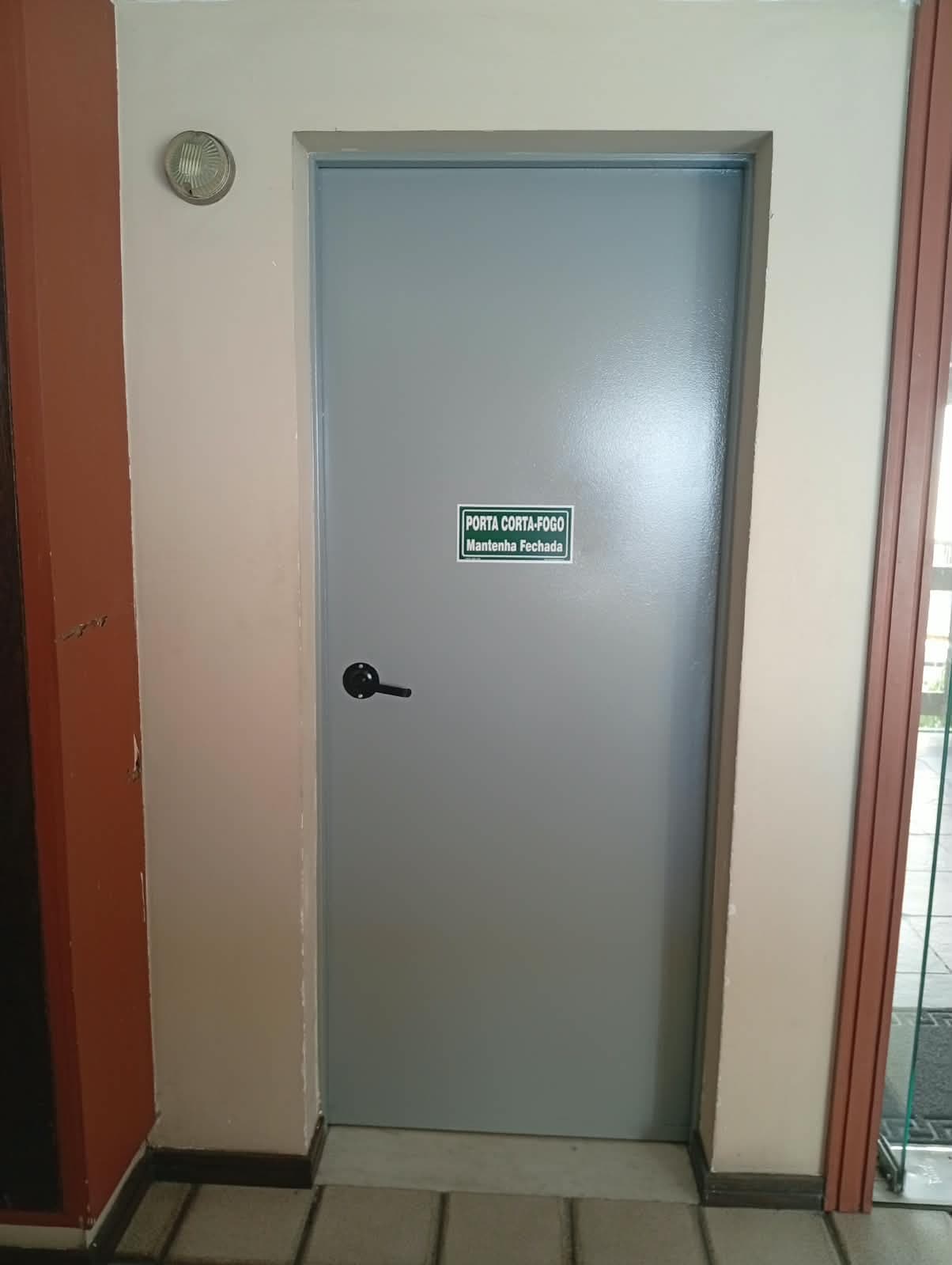 Porta corta-fogo cinza instalada e sinalizada
